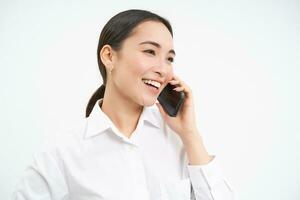 portret van Aziatisch zakelijke vrouw, zakenvrouw praat Aan mobiel telefoon, heeft gesprek over- mobiele telefoon, sprekend Aan telefoon, wit achtergrond foto