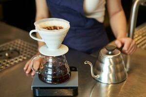 dichtbij omhoog van filter koffie brouwen uitrusting en ketel, cafe barista voorbereidingen treffen filter Bij de teller foto