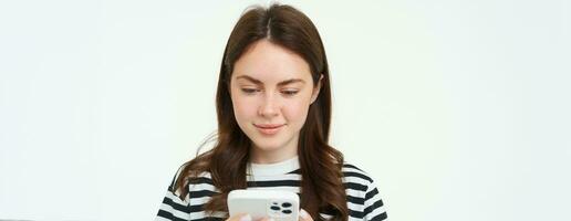 portret van vrouw controle haar berichten Aan mobiel telefoon, op zoek Bij smartphone scherm foto