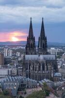 dramatisch storm wolken over- Keulen kathedraal en hohenzollern brug in de zonsondergang foto