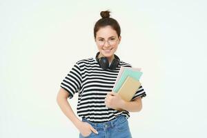 portret van lachend, zelfverzekerd jong vrouw, Holding notities, notebooks in haar handen, gaan naar middelbare school, leerling poseren tegen wit achtergrond foto