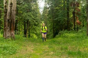 vrouw jogging Aan een spoor in een natuurlijk Woud park foto