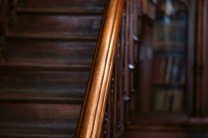 warm somber achtergrond, detail van een klassiek interieur, houten trappenhuis leuningen foto