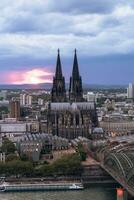dramatisch storm wolken over- Keulen kathedraal en hohenzollern brug in de zonsondergang foto
