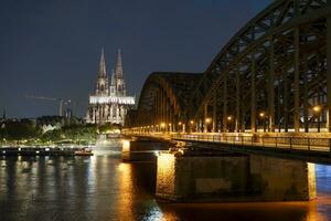 Keulen kathedraal en hohenzollern brug in de avond foto