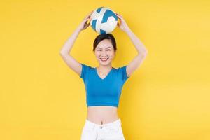 portret van jong dynamisch meisje met bal in de hand geïsoleerd op gele achtergrond foto