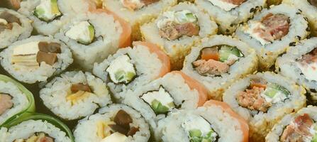 detailopname van een veel van sushi broodjes met verschillend vullingen. macro schot van gekookt klassiek Japans voedsel. achtergrond beeld foto
