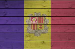 Andorra vlag afgebeeld in helder verf kleuren Aan oud houten muur. getextureerde banier Aan ruw achtergrond foto