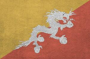 Bhutan vlag afgebeeld in helder verf kleuren Aan oud Verlichting bepleistering muur. getextureerde banier Aan ruw achtergrond foto