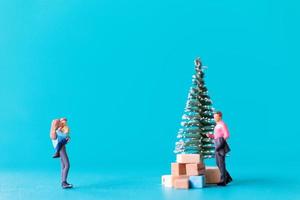 miniatuurmensen, gelukkige familie die naast een kerstboom staat foto