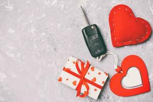 top visie van een Cadeau voor Valentijnsdag dag Aan houten achtergrond. auto sleutel, geschenk doos en hart met kopiëren ruimte. verrassing concept voor een vakantie foto