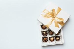 wit doos met chocolaatjes snoepjes en gouden plakband. top visie met kopiëren ruimte foto