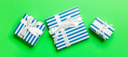 verpakt Kerstmis of andere vakantie handgemaakt Cadeau in papier met wit lint Aan groen achtergrond. Cadeau doos, decoratie van geschenk Aan gekleurde tafel, top visie foto