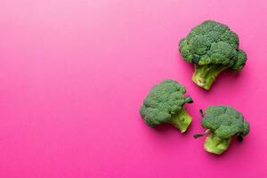 top visie vers groen broccoli groente Aan gekleurde achtergrond. broccoli kool hoofd gezond of vegetarisch voedsel concept. vlak leggen. kopiëren ruimte foto