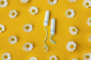 hygiënisch medisch vrouw tampon met kamilles in de omgeving van Aan een geel achtergrond. foto