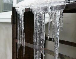 ijspegels Aan een metaal plank. winter seizoen. foto