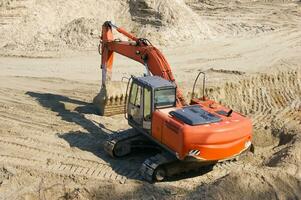 oranje graafmachine Aan een zand groeve. foto