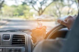 niet drinken en rijden concept, dronken en autorijden met een fles alcohol foto