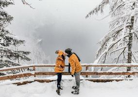 een jong stel deelt een kus bij sneeuwweer foto