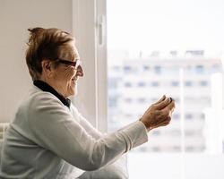 positieve oudere vrouw die thuis op videochat praat