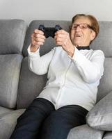 vrolijke senior vrouw die videogame speelt foto