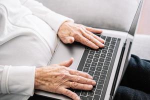 bejaarde vrouw bijsnijden met laptop thuis foto