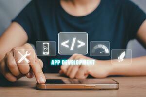 app ontwikkeling concept, persoon hand- gebruik makend van slim telefoon met app ontwikkeling icoon Aan virtueel scherm achtergrond, ontwerpen toepassing voor mobiel telefoon. foto