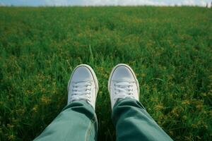 ai gegenereerd schoenen flair selfie van voeten in wit sportschoenen Aan gras foto