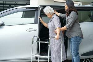 Aziatisch senior vrouw geduldig zittend Aan wandelaar bereiden krijgen naar haar auto, gezond sterk medisch concept. foto