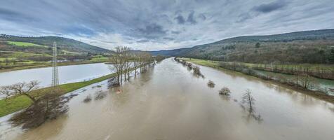 dar beeld van de Duitse rivier- hoofd gedurende een overstroming met overstroomd bomen Aan de banken foto