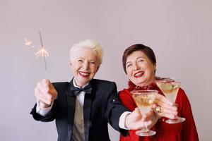 twee mooie stijlvolle volwassen senior vrouwen die nieuwjaar vieren. plezier, feest, stijl, feestconcept foto