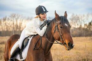 mooi blond professioneel vrouw jockey rijden een paard. vriendschap met paard. hoog kwaliteit foto