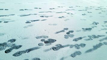 voetafdrukken Aan de besneeuwd oppervlak. sneeuw Hoes met menselijk voetafdruk foto