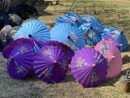 Thais paraplu's ambacht hand- geschilderd drogen in de zon buiten Bij een paraplu fabriek, Thailand, Chiang mei. foto