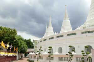 wit pagodes in kromme rij en grijs bewolkt lucht, wat gebedurawongswat Bangkok, Thailand. foto