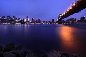 brooklyn bridge en de skyline van manhattan 's nachts nyc
