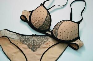 lingerie. reeks - beige sexy slipje met zwart kant en een beha Aan een wit achtergrond. modieus vrouwen ondergoed concept. foto