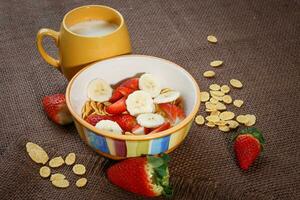 gezond ontbijt. cornflakes, vers aardbeien, banaan en melk foto