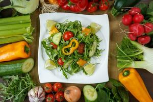 gezond aan het eten achtergrond. verschillend groenten en salade met blad groenten en kers tomaten Aan wit bord. foto