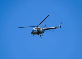 een helikopter van agrarisch luchtvaart is vliegend in de blauw lucht. foto