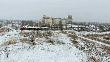 graan terminal in de winter seizoen. met sneeuw bedekt graan lift in landelijk gebieden. een gebouw voor drogen en opslaan korrel. foto