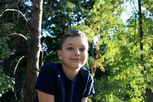 portret van een 9 jaar oud blond jongen in een herfst park. knap Kaukasisch jongen met groot ogen looks in de camera. foto