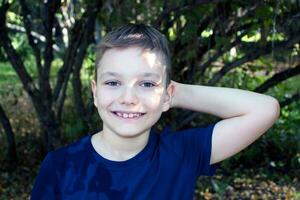 portret van een 9 jaar oud blond jongen in een herfst park. knap Kaukasisch jongen met groot ogen looks in de camera. foto