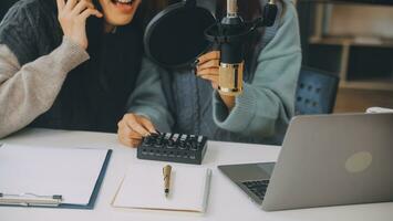 vrouw opname een podcast Aan haar laptop computer met hoofdtelefoons en een microscoop. vrouw podcaster maken audio podcast van haar huis studio. foto