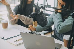 vrouw opname een podcast Aan haar laptop computer met hoofdtelefoons en een microscoop. vrouw podcaster maken audio podcast van haar huis studio. foto