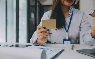 Dames Holding credit kaart en gebruik makend van smartphones Bij thuis.online winkelen, internet bankieren, op te slaan online, betaling, uitgeven geld, e-commerce betaling Bij de op te slaan, credit kaart, concept foto