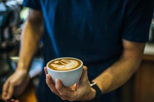 close-up van handen barista maakt latte koffie kunst verf foto