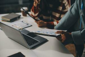 bedrijf team vergadering werken met nieuw opstarten projecteren, discussie en analyse gegevens de grafieken en grafieken. digitaal tablet, rekenmachine, laptop computer gebruik makend van, bedrijf financiën en accounting concept. foto