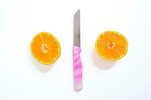 gesneden mandarijn geïsoleerd Aan een wit achtergrond met een mes. top visie, kopiëren ruimte. foto