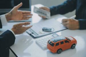 detailopname Aziatisch mannetje mensen auto verkoper of verkoop manager aanbiedingen naar verkopen een auto en legt uit en leest de voorwaarden van ondertekening een auto contract en verzekering. foto